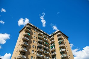 A high-rise building with multiple balconies and a clear blue sky. - 10 Floor Apartments (Como)