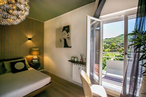 A modern bedroom with a bed, bedside table, lamp, and a view of a balcony. - 10 Floor Apartments (Como)