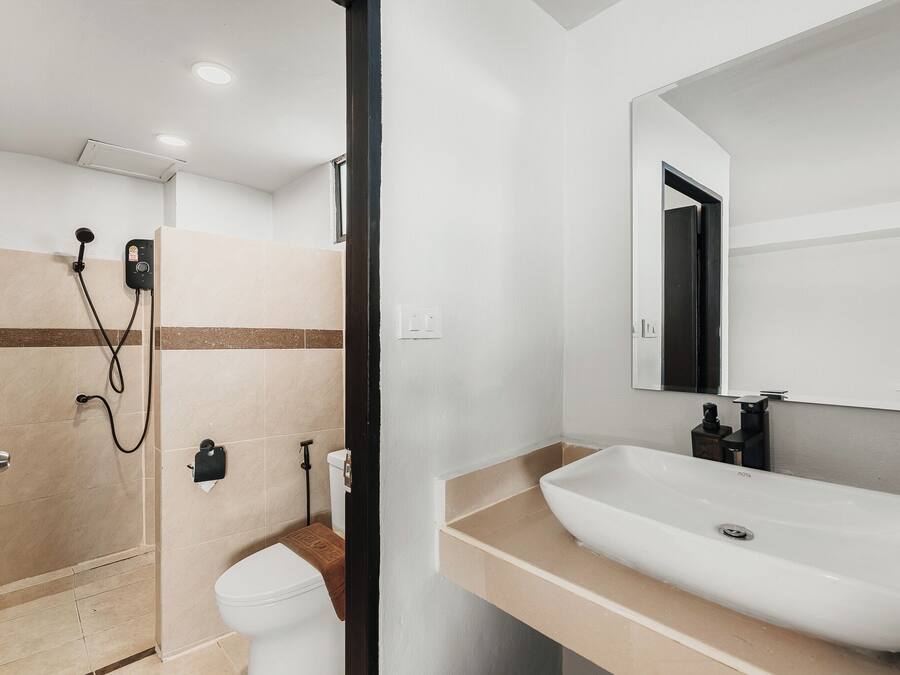 A modern bathroom with a shower, toilet, sink, and mirror.