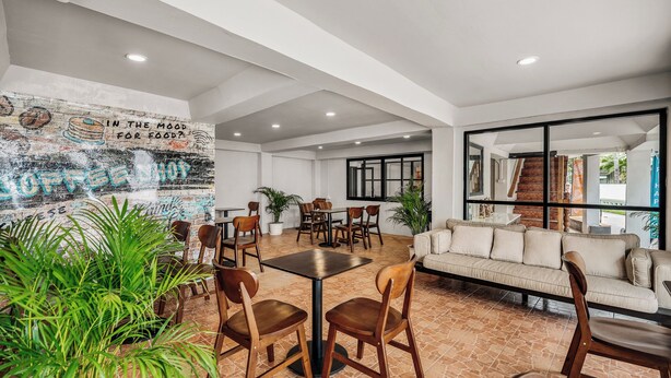 A modern interior with a dining area, a sofa, and a mural on the wall.