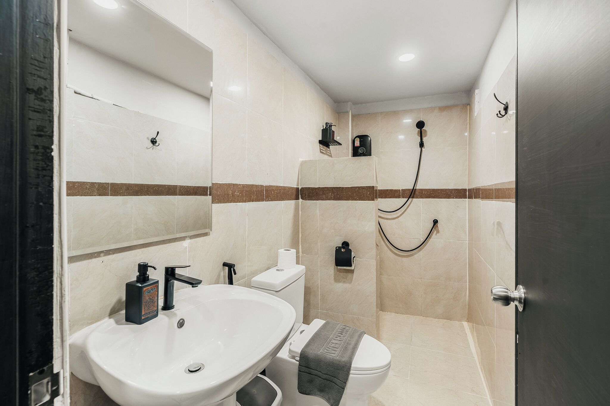 Baño con lavamanos, inodoro y ducha.