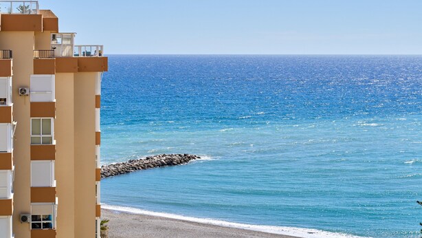 A coastal hotel with balconies, a beach view, and a rocky shoreline. - Apartment 'Studio Carabela' with Sea View, Wi-Fi and Air Conditioning (Torrox)