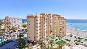 A multi-story hotel with balconies, a parking lot, and a beach view. - Apartment 'Studio Carabela' with Sea View, Wi-Fi and Air Conditioning (Torrox)