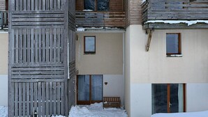 Un edificio de varios pisos con balcones de madera y una columna central.