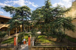 Ein Innenhof mit Brunnen, einem Weg und einem Gebäude mit Bögen.