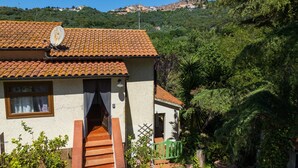A house with a tiled roof, a satellite dish, and a staircase leading to the entrance. - 'La Stanza di Campagna' with Shared Garden and Wi-Fi (Campiglia Marittima)