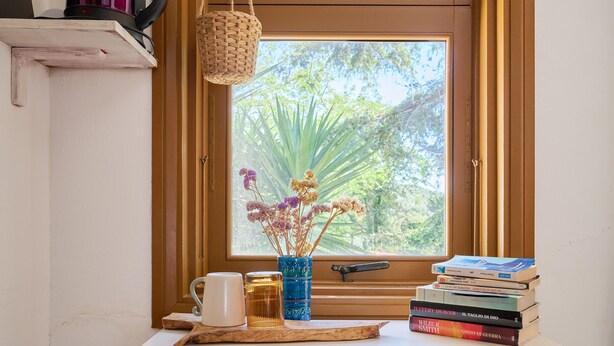 A desk with a vase of dried flowers, a mug, and a stack of books. - 'La Stanza di Campagna' with Shared Garden and Wi-Fi (Campiglia Marittima)