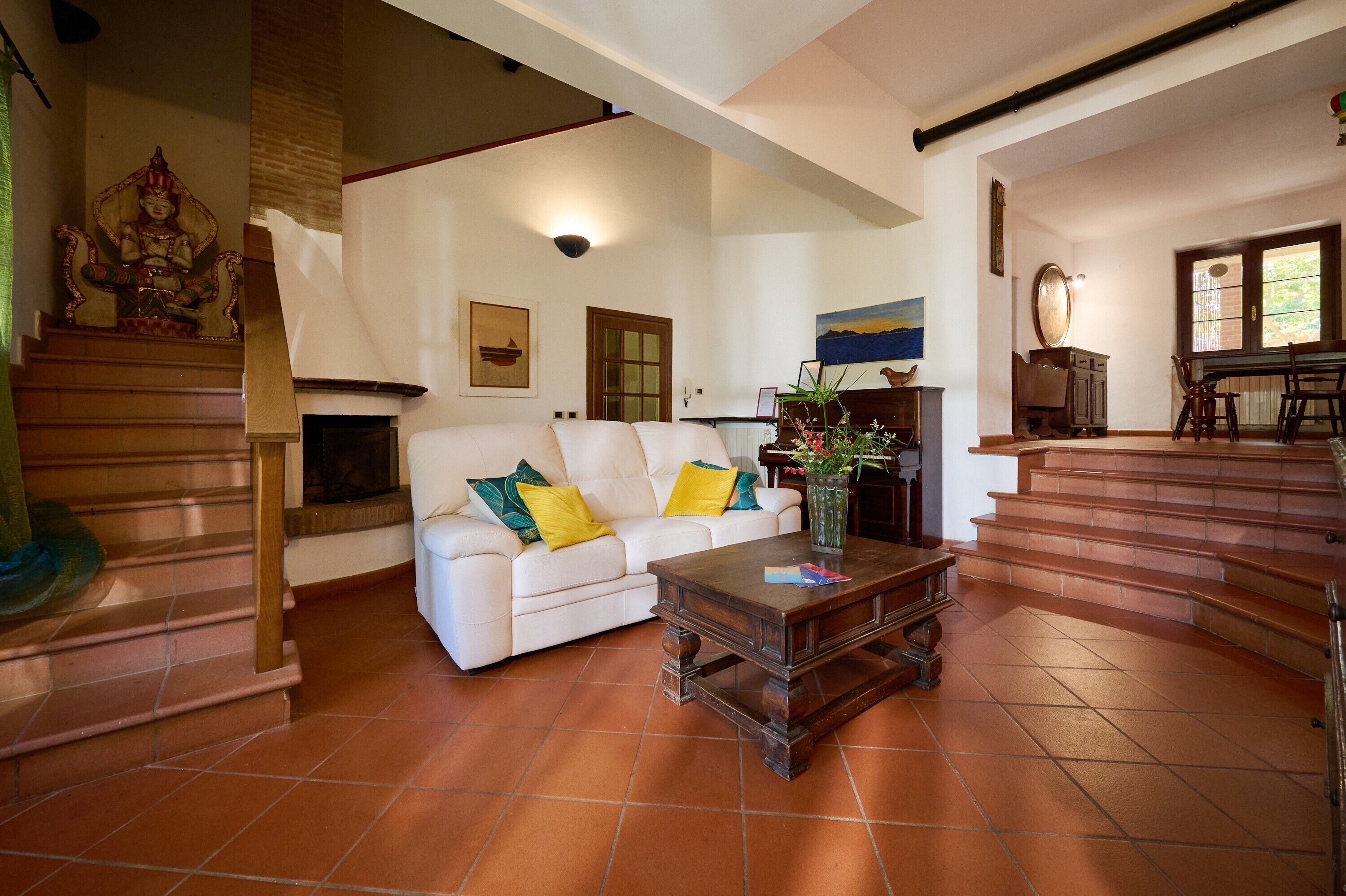 Ein Wohnzimmer mit einem weißen Sofa, einem Holztisch und einer Treppe.