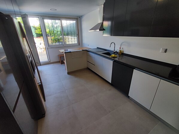 A modern kitchen with a black countertop, white cabinets, and a built-in oven.