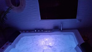 A bathtub filled with water and ice, with a control panel above it. - Luxury suite with private Jacuzzi and garden 20 minutes from Paris NetFlix (Saint-Prix)