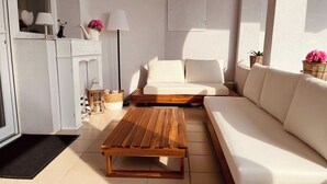 Una sala de estar moderna con una mesa de centro de madera, un sofá blanco y una lámpara.
