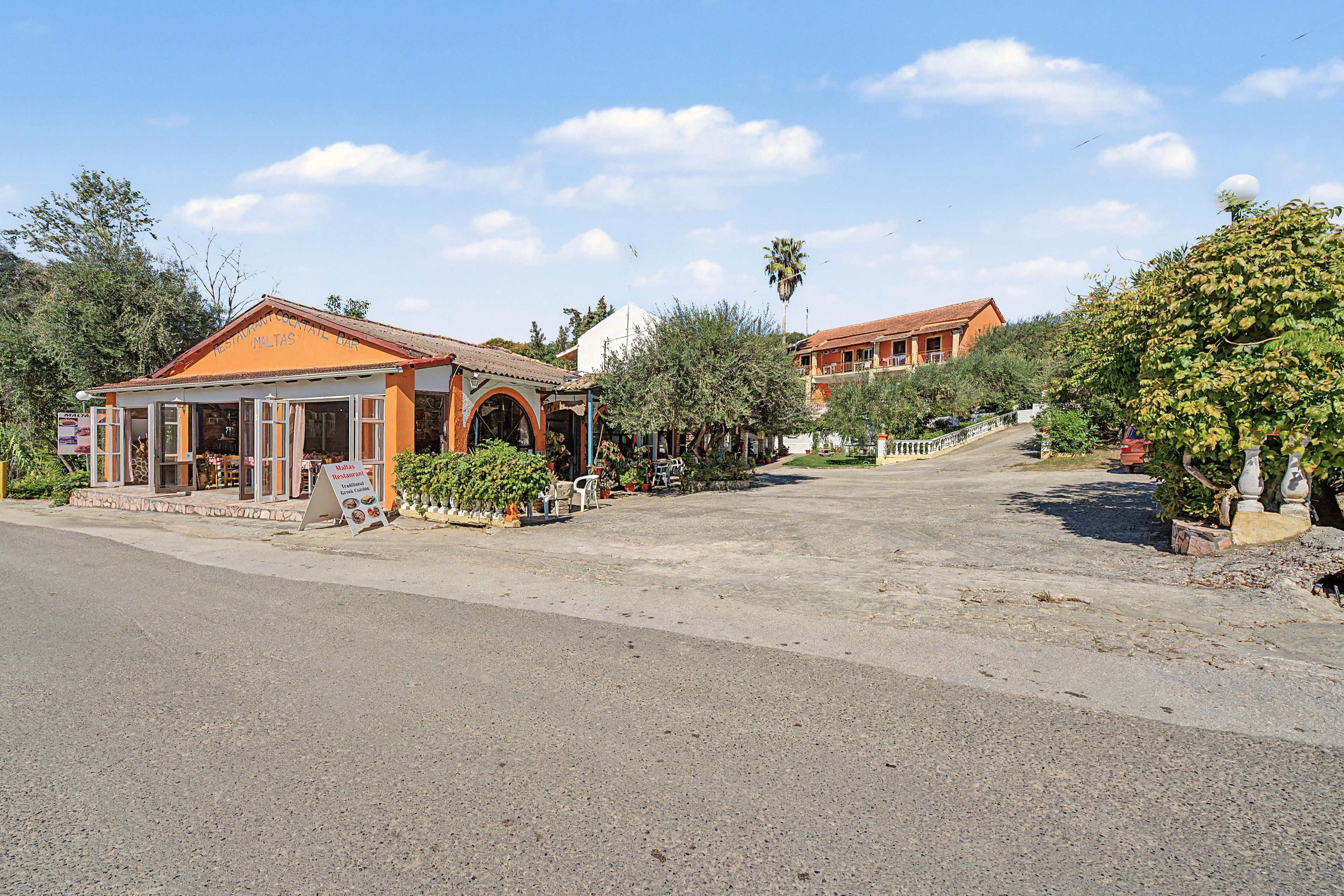 A restaurant with outdoor seating and a signboard.