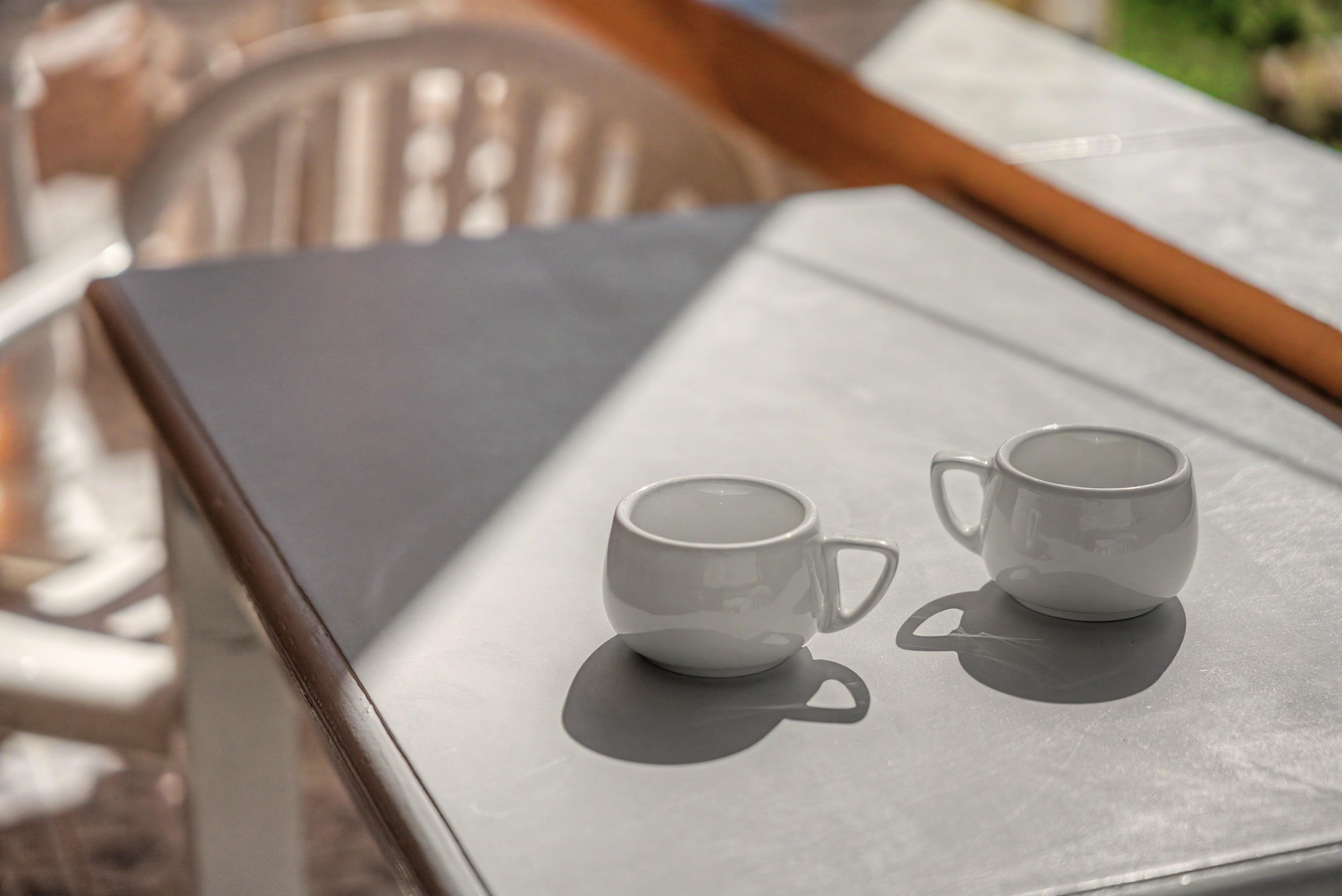 Une table avec deux tasses blanches posées sur un plateau.