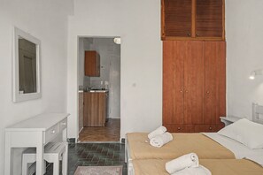 A bedroom with a bed, a bedside table, a wooden wardrobe, and a bathroom visible through an open door. - Studio Apartment 'Maltas 6' with Shared Terrace, Wi-Fi and Air Conditioning (Corfu)