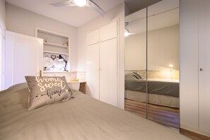 A bedroom with a bed, a bedside table, a mirror, and a wardrobe. - M (OLM102BA) Spacious and bright apartment for 2 bedrooms (Madrid)