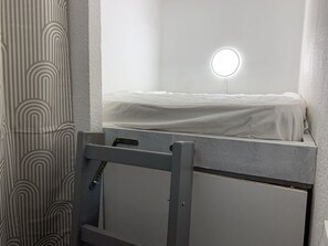 A small, enclosed bathroom with a toilet, a mirror, and a light fixture above the mirror. - Apartment with AC, sea view - 4 guests (Hyères)