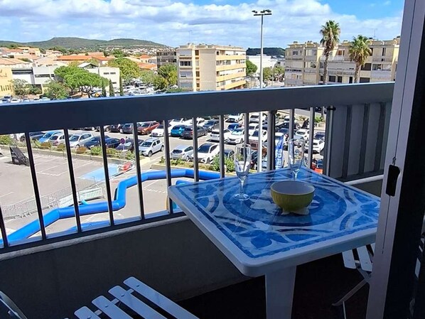 A balcony with a view of a parking lot and buildings. - Cozy studio, pets allowed - 2 guests (Balaruc-les-Bains)