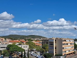 A cityscape with a clear sky, buildings, and a parking lot. - Cozy studio, pets allowed - 2 guests (Balaruc-les-Bains)