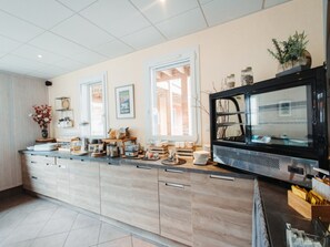 Una cocina moderna con una isla grande, armarios empotrados y un refrigerador negro.