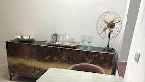 Spiseområde med et bord, stole, et pynteskab og en gulvlampe.