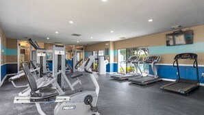 Ein Fitnessstudio mit verschiedenen Cardiogeräten und Krafttrainingsgeräten, darunter Laufbänder und Gewichtsmaschinen.