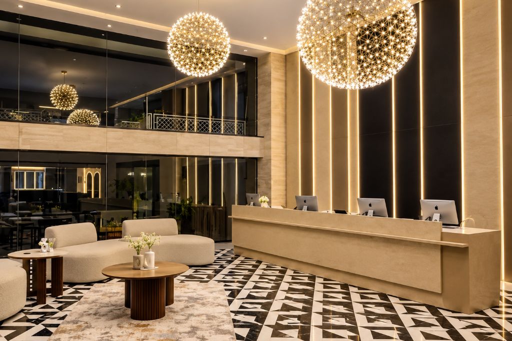 Un vestíbulo de hotel moderno con mostrador de recepción, zona de estar y suelo estampado.