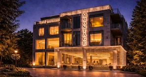 Un hôtel moderne, reconnaissable à son grand panneau « Montage », à ses larges fenêtres et à son entrée bien éclairée.