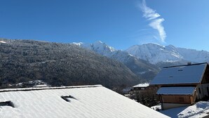 A snow-covered mountain landscape with a clear sky and a visible contrail. - 42m2 triplex near St-Gervais return runway (Saint-Gervais-les-Bains)