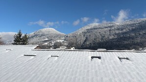 A snow-covered landscape with a mountain in the background and a building with a flat roof in the foreground. - 42m2 triplex near St-Gervais return runway (Saint-Gervais-les-Bains)