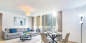 A modern living room with a sofa, coffee table, and dining table. - LUX  Contemporary Suite with Full Marina View 6 (Dubai)