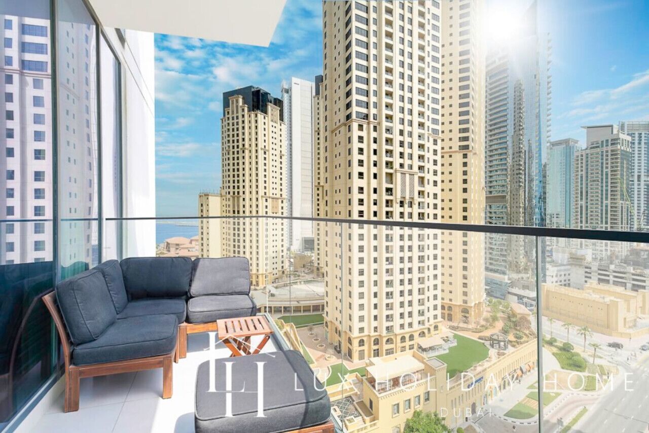 Een modern appartement met balkon, grote ramen en uitzicht op hoge gebouwen.