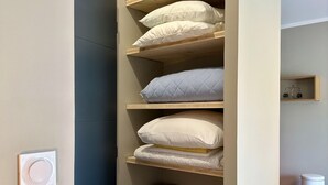 Ein kleines Zimmer mit einem Etagenbett, einem kleinen Holzhocker und einer Wandablage mit dekorativen Gegenständen.