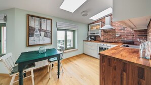 Eine moderne Küche mit Backsteinwand, Holz Arbeitsplatte und einem Essbereich mit Tisch und Stühlen.