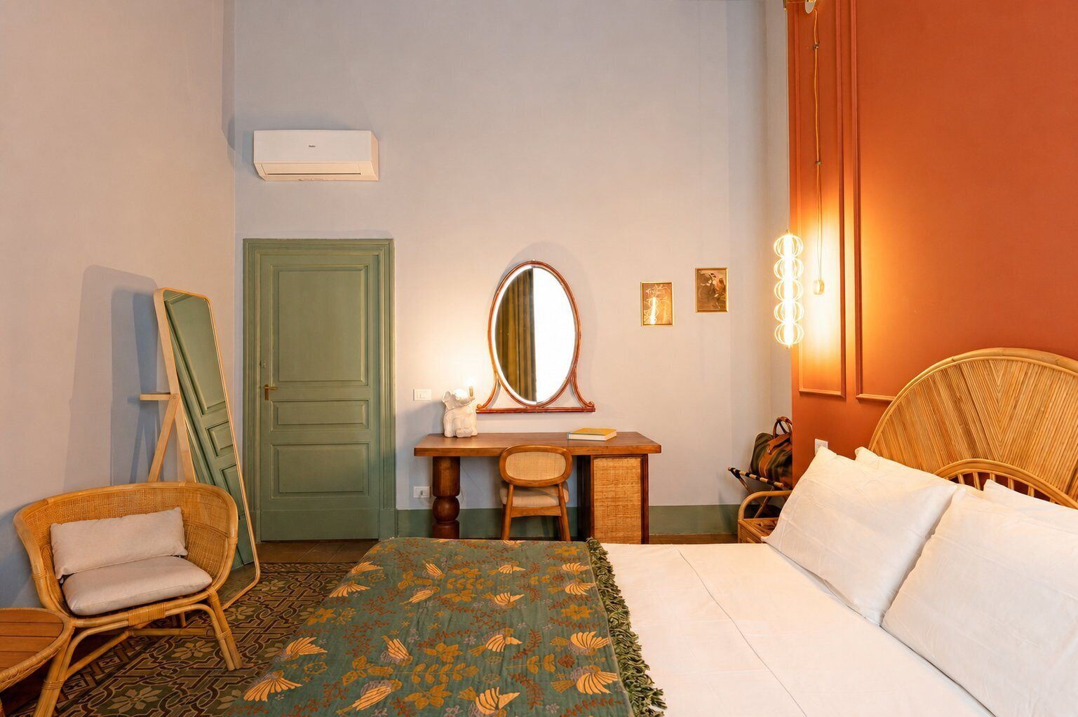 Une chambre à coucher avec un lit, un bureau doté d’un miroir, une chaise, une commode et une porte.