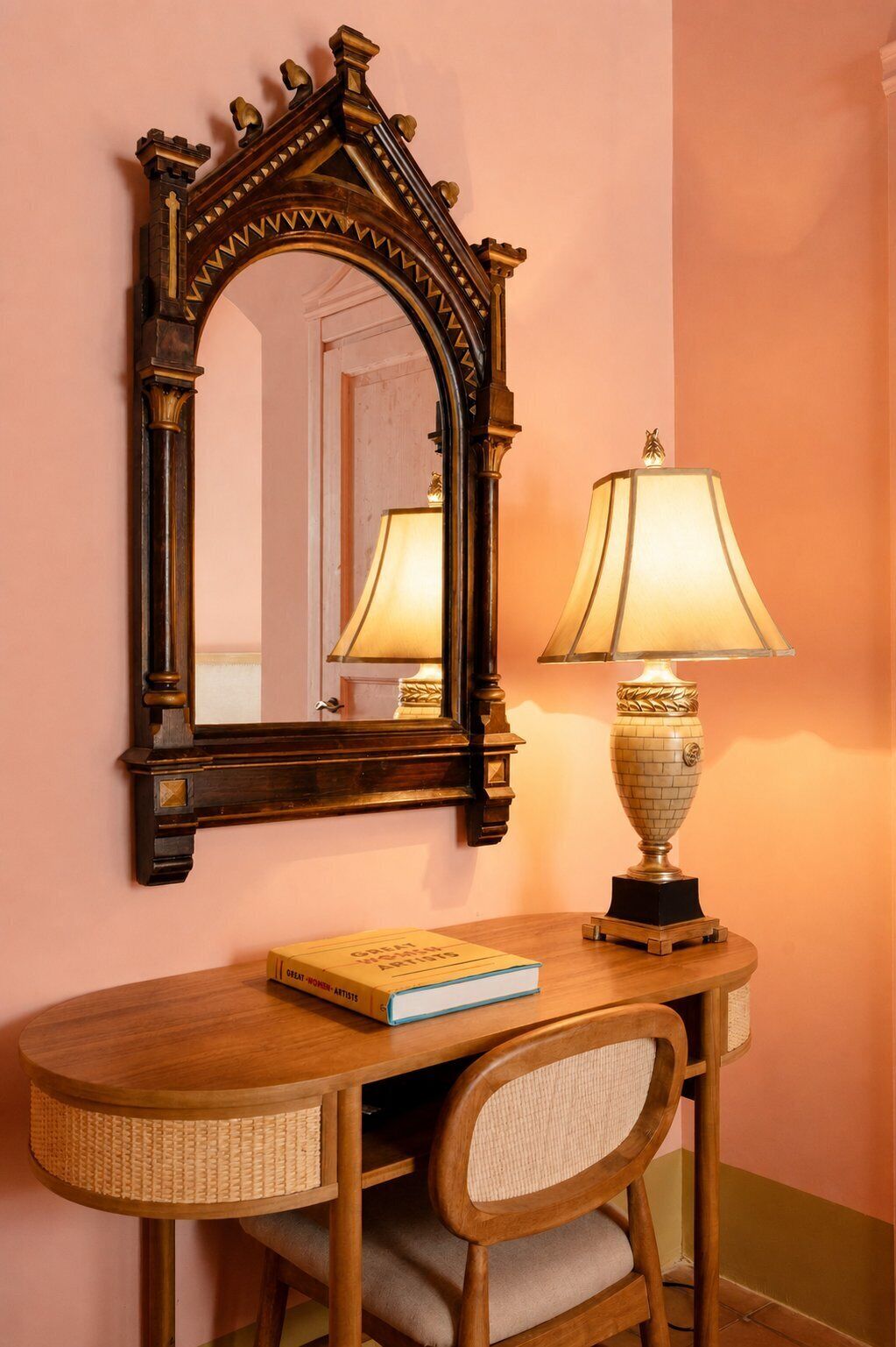A wooden desk with a mirror, a lamp, and a book.