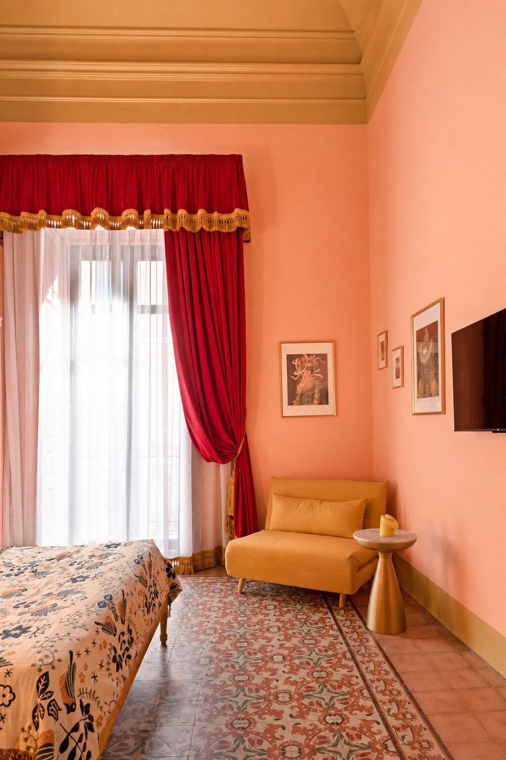 A room with a bed, a chair, a small table, and a wall-mounted TV.