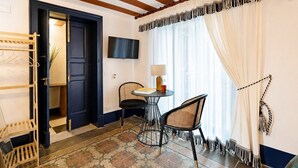 A room with a dark door, a small table with a lamp, two chairs, and a patterned floor. - Le Stanze di Monserrato (Catania)