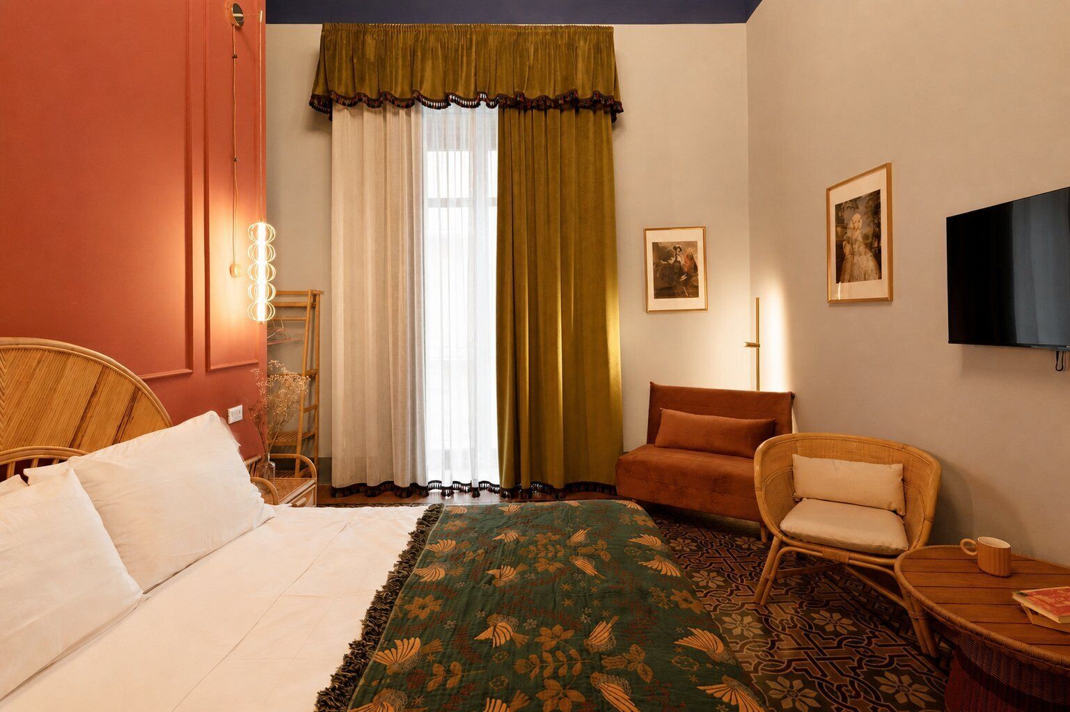 Ein Hotelzimmer mit einem Bett, zwei Stühlen, einem Fernseher und einem Fenster mit Vorhängen.