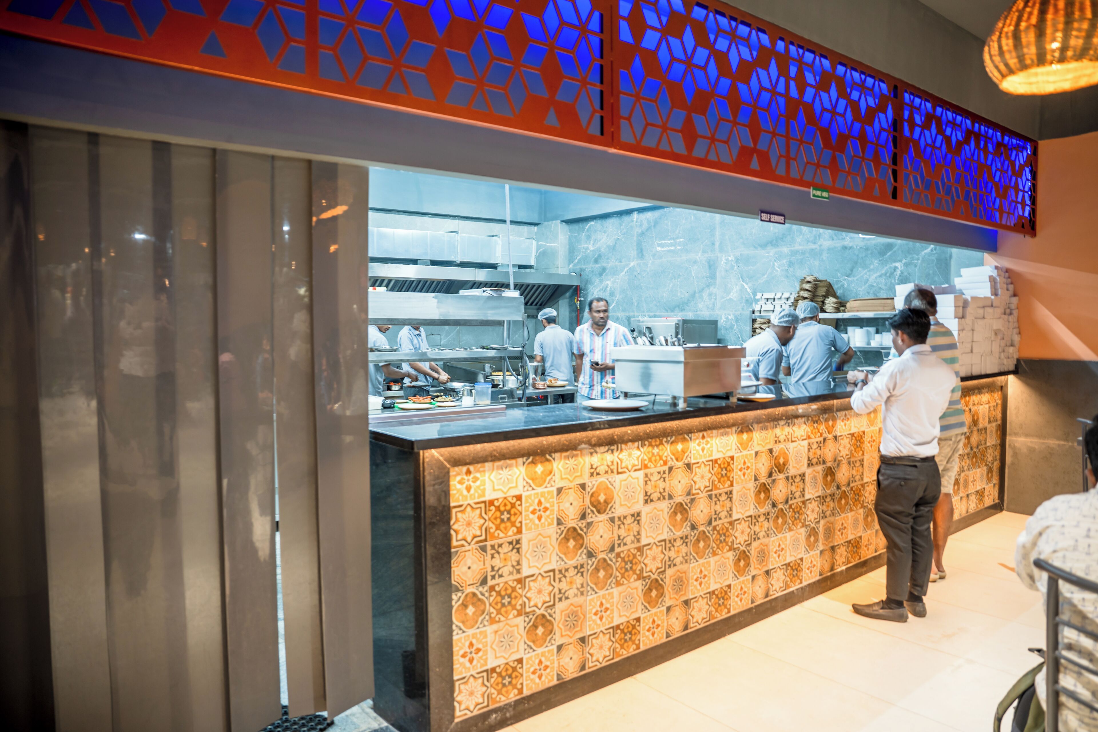 Un restaurant avec un comptoir carrelé et un plafond décoratif.