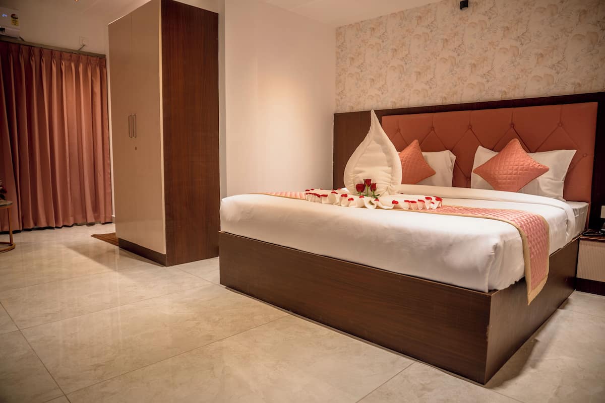 Un dormitorio bien iluminado con una cama grande, un armario de madera y un papel tapiz estampado.