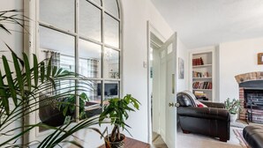 Un salon avec une cheminée, un canapé, une table basse et une bibliothèque.