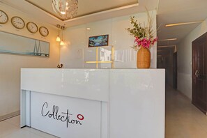 A reception desk with a sign reading "Collection" and a decorative vase with flowers. - Hotel O by OYO New Hotel Hamsa (Hyderabad)