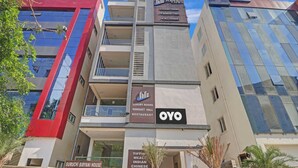 A hotel with multiple floors, including a visible restaurant and a sign for luxury rooms and a banquet hall. - Hotel O by OYO New Hotel Hamsa (Hyderabad)