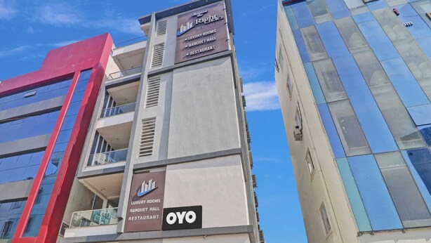 A modern building with signage for 'Rico's the Richest' and 'OYO' indicating luxury rooms, a banquet hall, and a restaurant. - Hotel O by OYO New Hotel Hamsa (Hyderabad)