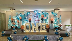 A stage with a large 'ONE' sign, surrounded by blue and silver balloons, and a backdrop with 'Happy Birthday ANVIT' text. - Hotel Shivam by Greenwoods Resorts (Kudal)