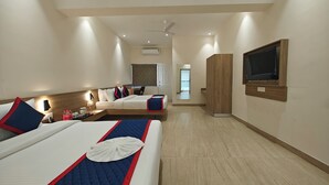 A hotel room with two beds, a TV, a wardrobe, and a bathroom visible in the background. - Hotel Shivam by Greenwoods Resorts (Kudal)
