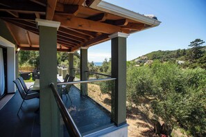 A covered outdoor seating area with a view of the landscape. - Villa Socrates Gardeno Luxury Sea View Pool Escape (Corfu)