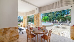 A covered outdoor dining area with stone pillars, a pool, and a fenced garden. - Villino Salentum With Private Pool and Garden (Racale)