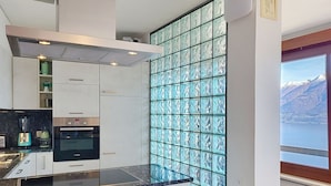 Eine moderne Küche mit Backofen, einem Bosch Geschirrspüler und einem großen Fenster mit Bergblick.