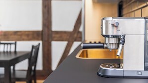 Una cocina moderna con una cafetera espresso integrada, una mesa de comedor de madera y sillas.
